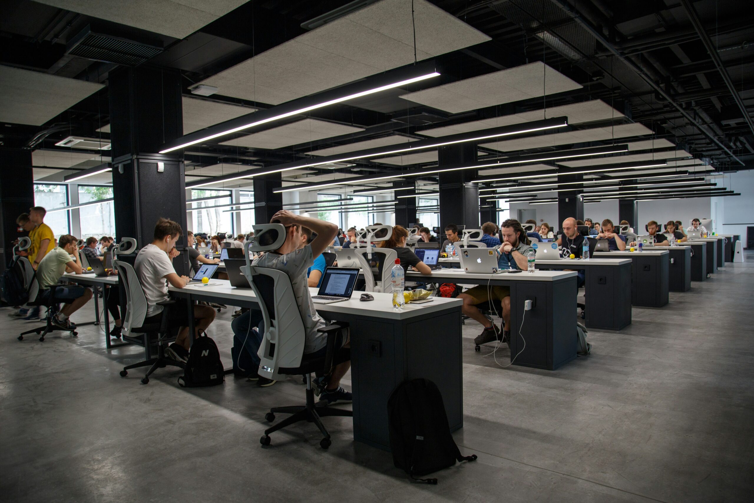 Large open office space with rows of desks and people working